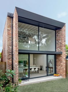 a brick house with glass walls and sliding doors