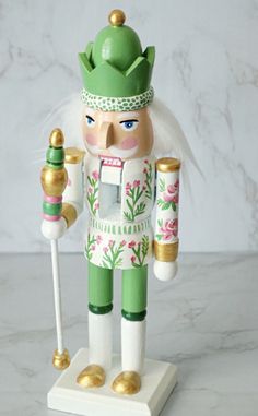 a nutcracker figurine holding two candy canes on a marble surface