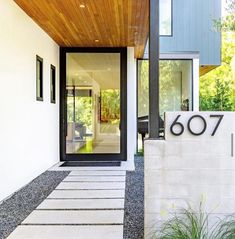 the entrance to a modern home with black and white accents