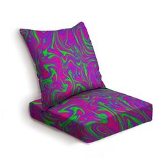 a purple and green chair cushion with an abstract design on the back side, sitting in front of a white background