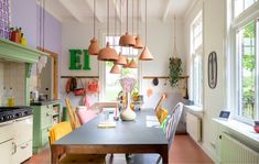 a kitchen filled with lots of counter top space and colorful lights hanging from the ceiling