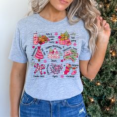 a woman standing next to a christmas tree wearing a t - shirt that says happy holidays