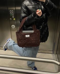 a woman taking a selfie with her cell phone in front of an escalator