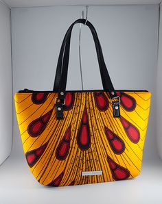 "\"Bag description:  This lovely bag is a perfect size for any occasion, with ample room for all your essentials when shopping, going to the office or on an evening out. The peacock design in yellow and wine also look great against a little black dress brightening the autumn day. This tote bag is a combination of Ankara African fabric and faux leather, fully lined waterproof canvas fabrics. The handles are long enough to fit comfortably on the shoulder or held by hand. Internally, this bag is fully lined with waterproof canvas and zippered pocket which fits your phone or other valuables. This bag is closed with a durable zip. Bag Style: Tote Fabric: African Wax Print Fabric - Ankara yellow and wine print fabric. 100% Cotton Lining: Waterproof canvas Hardware: Chrome  Handles: 24 inches in Yellow Large Capacity Box Shoulder Bag, Yellow Top Handle Bag As Gift, Trendy Yellow Bag With Removable Pouch, Satchel Box Bag, Trendy Large Capacity Yellow Box Bag, Trendy Large-capacity Yellow Box Bag, Large Capacity Yellow Box Bag For Everyday Use, Yellow Top Handle Box Bag With Large Capacity, Elegant Multicolor Bags For On-the-go