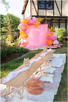 An image of a sorority charcuterie picnic event. There are low picnic tables, rugs, and pillows on the front yard, with a balloon garland and neon sign photo backdrop. Sorority Moms Day Ideas, Sorority Parents Weekend Activities, Sorority Moms Day Activities, Sisterhood Retreat Banner, Sorority Sisterhood Retreat Ideas, Spring Recruitment Ideas, Sorority Retreat Themes, Moms Day Sorority Activities, Sisterhood Sorority Ideas