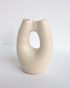 a white vase sitting on top of a table