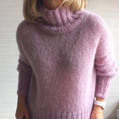 a woman wearing a pink sweater and jeans