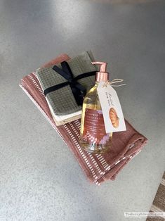 a bottle of liquid sitting on top of two napkins next to each other with a tag