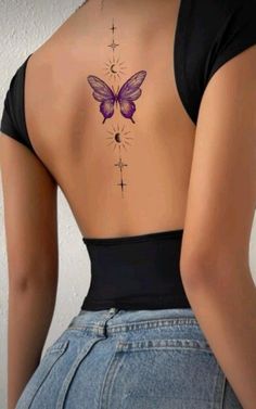 the back of a woman's body with a butterfly tattoo on her lower back