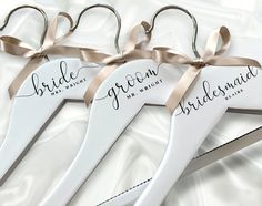 three pairs of personalized wedding hangers with ribbons