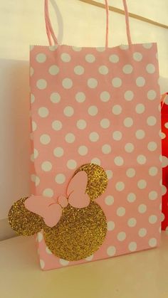 a pink and white polka dot paper bag with minnie mouse on it, sitting on a table