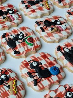 decorated cookies with black and white designs on red and white checkered tablecloths