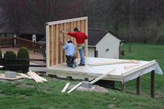 two men standing on top of a wooden structure