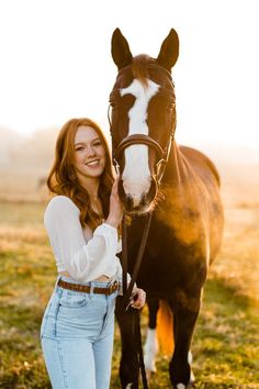 a woman standing next to a brown and white horse