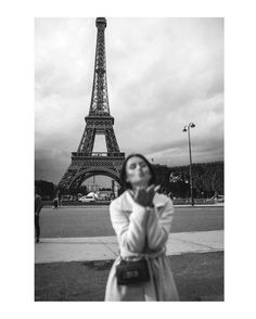 black and white photograph of woman in front of the eiffel tower, paris