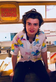 a man sitting on top of a counter in a kitchen