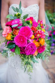 a bride holding a colorful bouquet of flowers