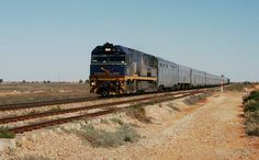 a train is traveling down the tracks in the desert