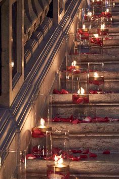 many candles are lit on the steps outside