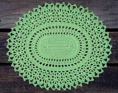 green crocheted doily on wooden background