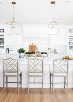 three chairs sit at the center of a kitchen island