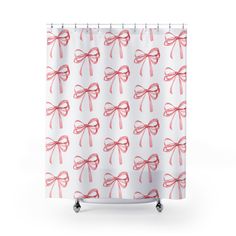 a white shower curtain with pink bows on the top and bottom, in front of a white background