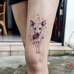 a small dog with flowers on its leg is shown in this tattoo design by the artist