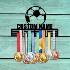 three medals with the words custom name and five ribbons in front of them on a wooden background