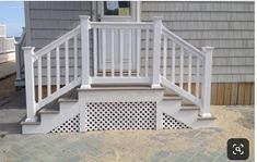 a white porch with pergolated steps and railings on the side of a house