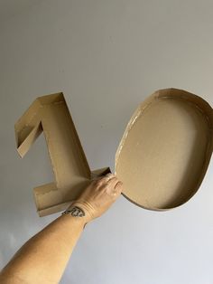 a person is holding up a cardboard letter