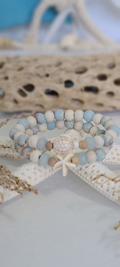 TitiTataStore.etsy.com Always FREE SHIPPING and a FREE GIFT! I Will Ship Within 24 Hours! Description: A set of 2 Coastal Style Beach Bracelets. The perfect accessory for that beach getaway vacation trip!  Materials:  8mm Sea Sediment Jasper Beads, 8mm Natural Wood Beads, 8mm Faceted Aquamarine Blue Rondelle Quartz Beads, and 6mm Sandalwood Beads.  A Sea Turtle and a Starfish charm adorned this Coastal style  set.  A high-quality elastic stretch cord is used to string the beads together.  Size: Sea Jewelry Aesthetic, Pretty Beaded Jewelry, Aesthetic Bracelets, Beachy Bracelets, Sand Gifts, Ocean Bracelet, Girls Trip Gifts, Sea Turtle Bracelet, Ocean Eyes