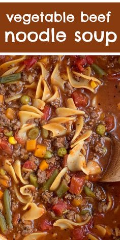 vegetable beef noodle soup in a large pot with a wooden spoon on the side