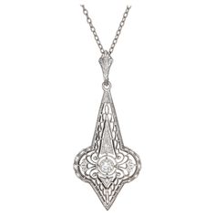 1930's filigree Art Deco pendant necklace. Old Euro center diamond in 14k white gold on a 16 inch 14k white gold chain. Front of the pendant is white gold with a 14k yellow gold back. 1 old euro diamond approx total weight: .10cts G, VS2 Chain length: 16 inches 14k white and yellow gold Length: 1.40 inches or 35.65mm Width: .61 inches or 15.56mm Gold Filigree Necklace, Art Deco Pendant Necklace, Diamond Drop Pendant, Filigree Pendant Necklace, White Gold Pendant Necklace, Art Deco Gold, Filigree Necklaces, Art Deco Pendant, Drop Pendant Necklace