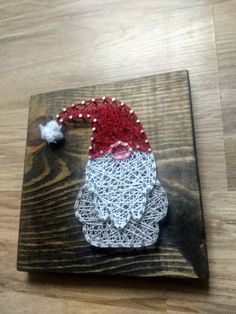 a piece of string art with a santa hat on it