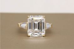 an emerald cut diamond ring with three baguets