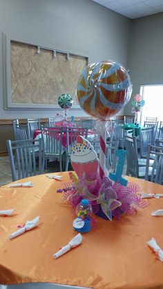 an orange table with balloons and streamers on it