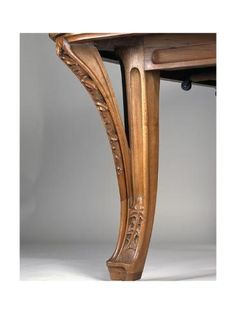 a wooden table with carvings on the top and bottom, sitting against a white background