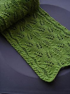 a green knitted blanket sitting on top of a car