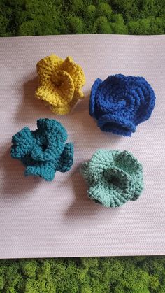 three crocheted flowers sitting on top of a mat