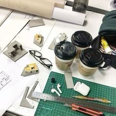 some coffee cups sitting on top of a table next to a ruler and other items