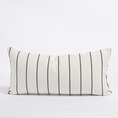 a black and white striped pillow on a white background with an embroidered strip design in the middle