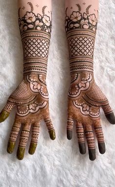 two hands with henna tattoos on them