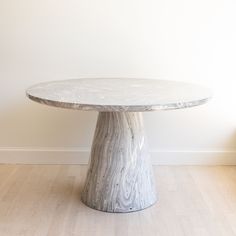 a white marble table sitting on top of a hard wood floor