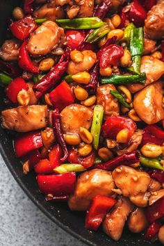 a pan filled with chicken and vegetables on top of a table