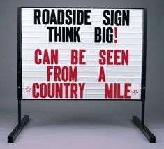 a sign that says roadside sign think big can be seen from a country mile on it