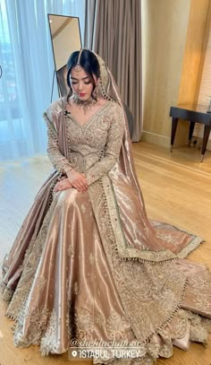 a woman in a bridal gown sitting on the floor with her hand on her knee