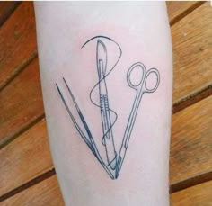 a tattoo with scissors and needles on it