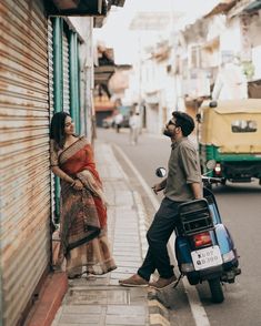 a man standing next to a woman on a scooter