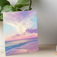 an ocean scene with waves crashing on the shore and pink clouds in the sky art board print