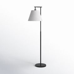 a black floor lamp with a white shade on the base and a light bulb attached to it